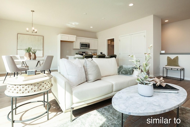 living area featuring a notable chandelier, wood finished floors, recessed lighting, and baseboards