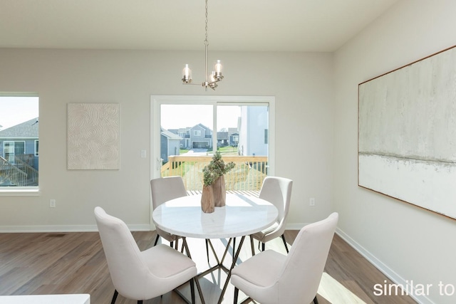 dining area with an inviting chandelier, wood finished floors, and baseboards