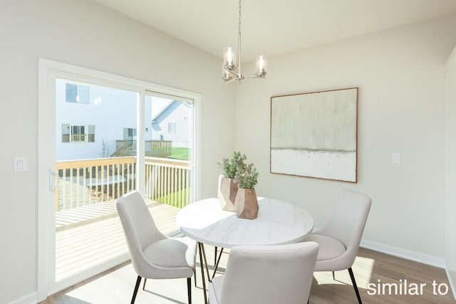 dining area with a notable chandelier, baseboards, and wood finished floors