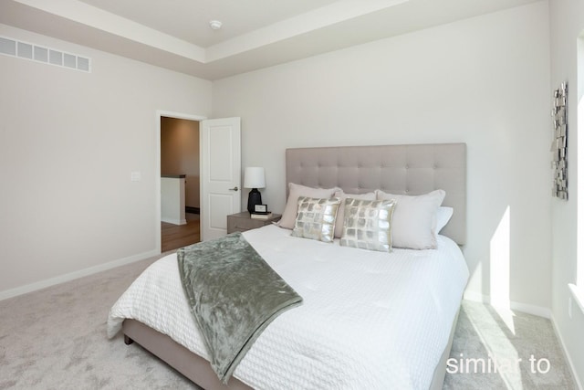 carpeted bedroom with visible vents and baseboards