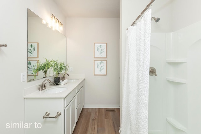 full bath with a sink, a shower with curtain, and wood finished floors