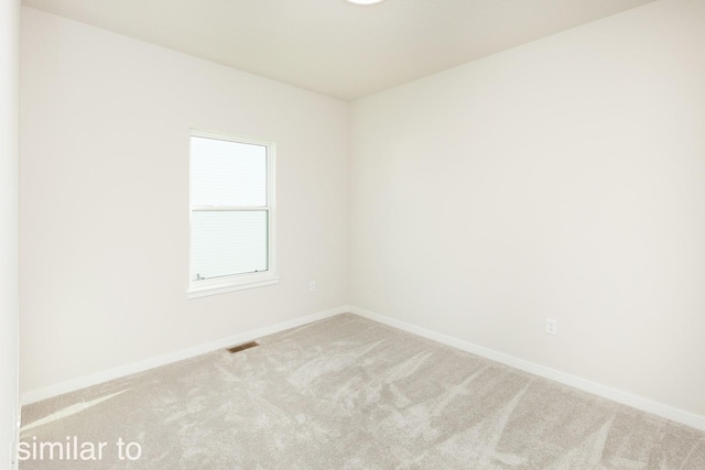 carpeted empty room featuring visible vents and baseboards