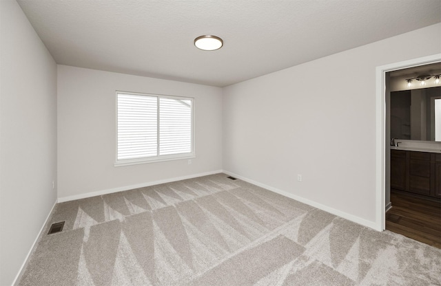 carpeted empty room with baseboards and visible vents