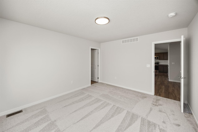 unfurnished bedroom with baseboards, visible vents, and carpet