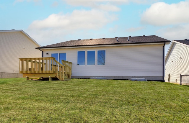 rear view of house featuring a lawn, fence, and a deck