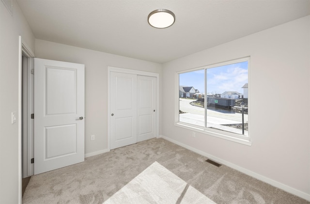 carpeted bedroom with baseboards, visible vents, and a closet