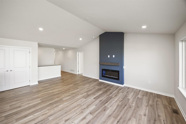 unfurnished living room with visible vents, a large fireplace, light wood finished floors, and recessed lighting