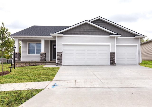 1099 NE 64th Ave, Des Moines, IA 50313 - craftsman house featuring a garage, stone siding, concrete driveway, and a front yard