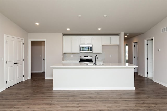 1099 NE 64th Ave, Des Moines, IA 50313 - kitchen featuring appliances with stainless steel finishes, white cabinetry, wood finished floors, light countertops, and recessed lighting