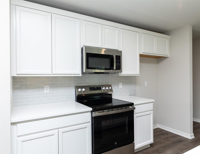 1099 NE 64th Ave, Des Moines, IA 50313 - kitchen featuring stainless steel appliances, dark wood-style floors, baseboards, white cabinetry, and tasteful backsplash