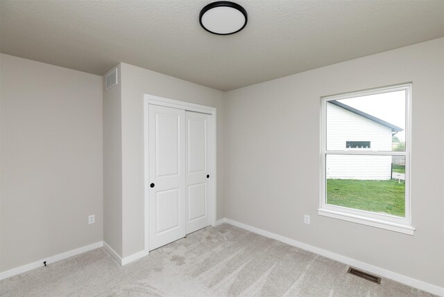 1099 NE 64th Ave, Des Moines, IA 50313 - unfurnished bedroom featuring light carpet, a closet, and baseboards