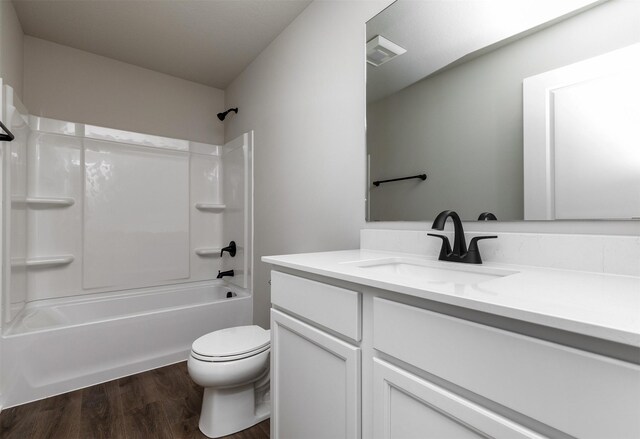1099 NE 64th Ave, Des Moines, IA 50313 - bathroom with vanity, wood finished floors, toilet, and bathing tub / shower combination