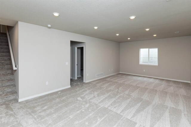 1099 NE 64th Ave, Des Moines, IA 50313 - unfurnished room with light colored carpet, stairway, baseboards, recessed lighting, and a textured ceiling
