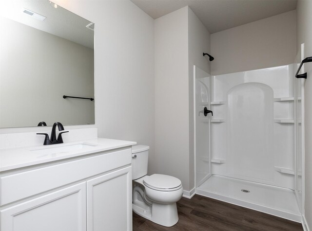1099 NE 64th Ave, Des Moines, IA 50313 - full bath with wood finished floors, a shower, toilet, vanity, and baseboards