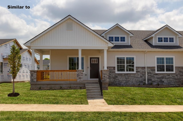 view of front of property featuring covered porch, roof with shingles, and a front lawn