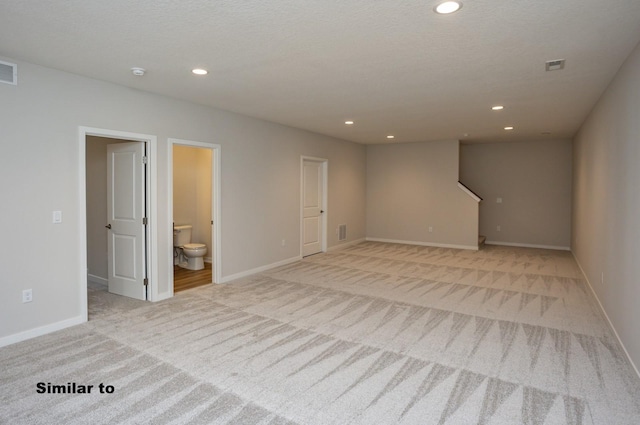 unfurnished room with recessed lighting, light colored carpet, and baseboards