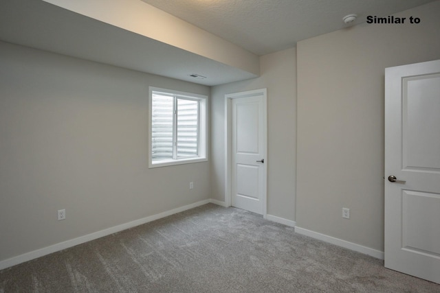 unfurnished bedroom with light carpet, a textured ceiling, and baseboards