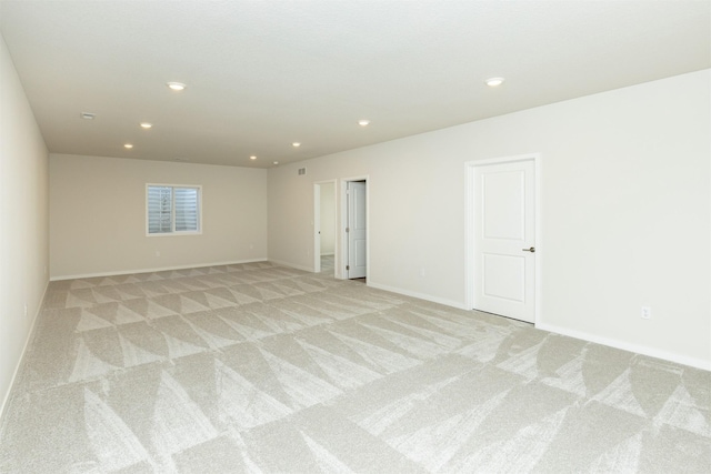 spare room featuring recessed lighting, baseboards, and light carpet