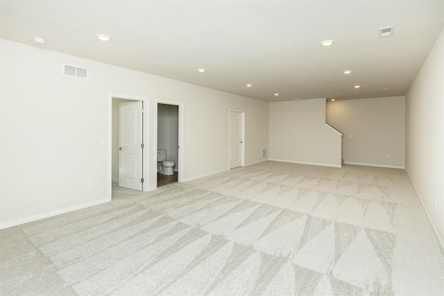 empty room with baseboards, light carpet, visible vents, and recessed lighting