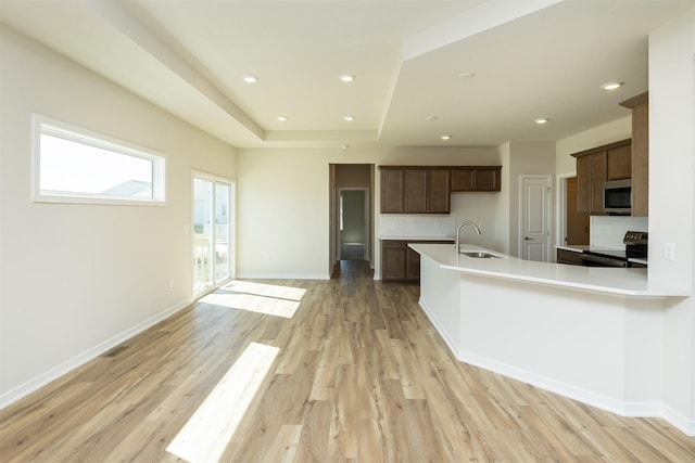 kitchen featuring light countertops, a sink, appliances with stainless steel finishes, and tasteful backsplash