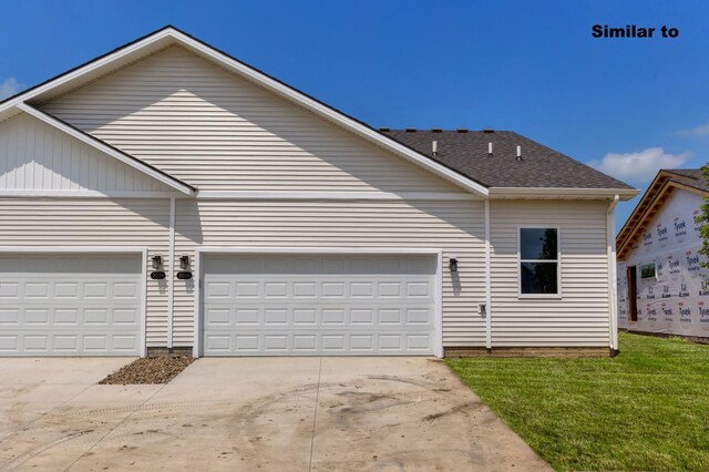 view of front of property with concrete driveway, a front lawn, and an attached garage