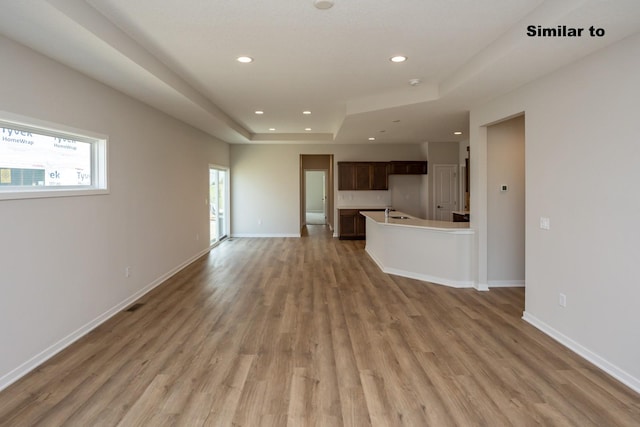 unfurnished living room with recessed lighting, light wood finished floors, and baseboards