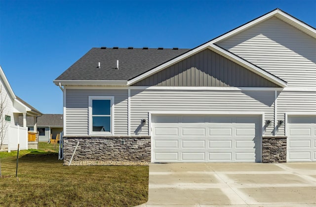 craftsman inspired home with an attached garage, driveway, and stone siding