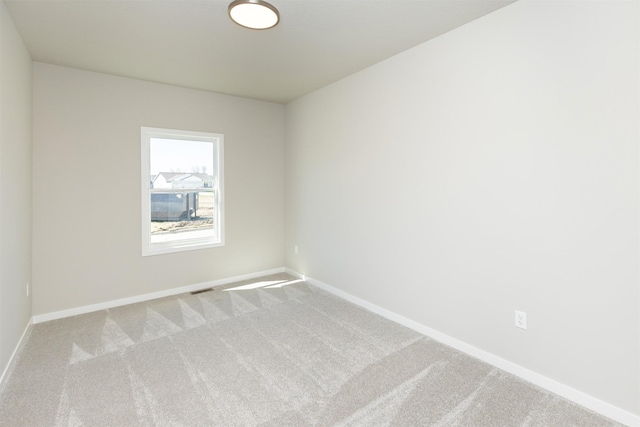 spare room featuring visible vents, baseboards, and carpet flooring