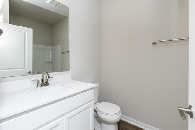 full bath with wood finished floors, visible vents, toilet, vanity, and baseboards