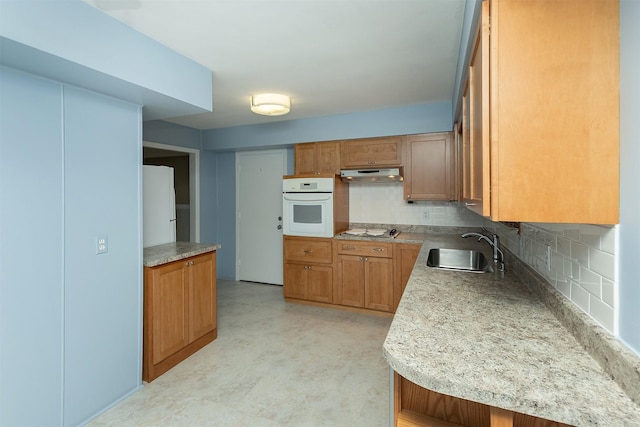 kitchen with sink, backsplash, and white appliances