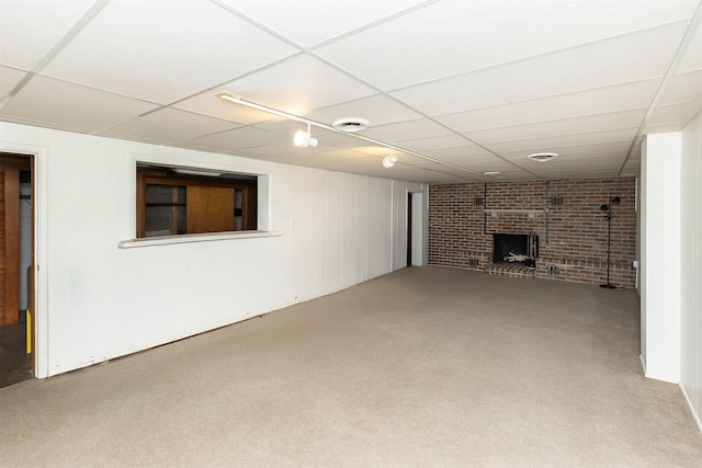 basement featuring carpet, a paneled ceiling, and a fireplace