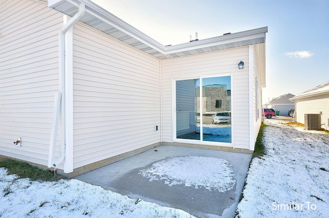 snow covered property entrance featuring central air condition unit