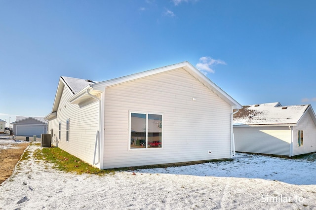 snow covered rear of property with central AC unit