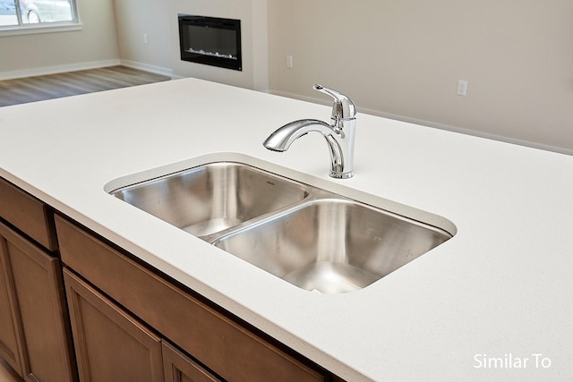 interior details with brown cabinets, light countertops, and a sink