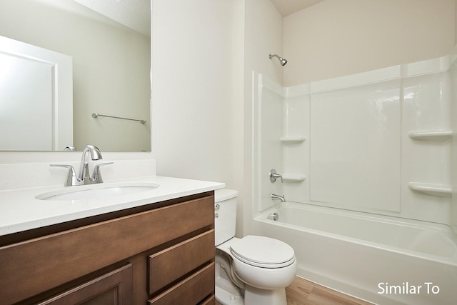 bathroom with wood finished floors, bathing tub / shower combination, vanity, and toilet