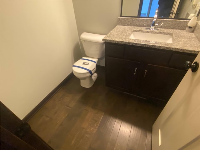 bathroom with hardwood / wood-style flooring, vanity, and toilet