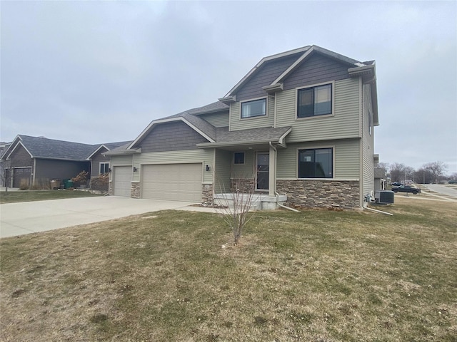 view of front of property with central AC, a front yard, and a garage