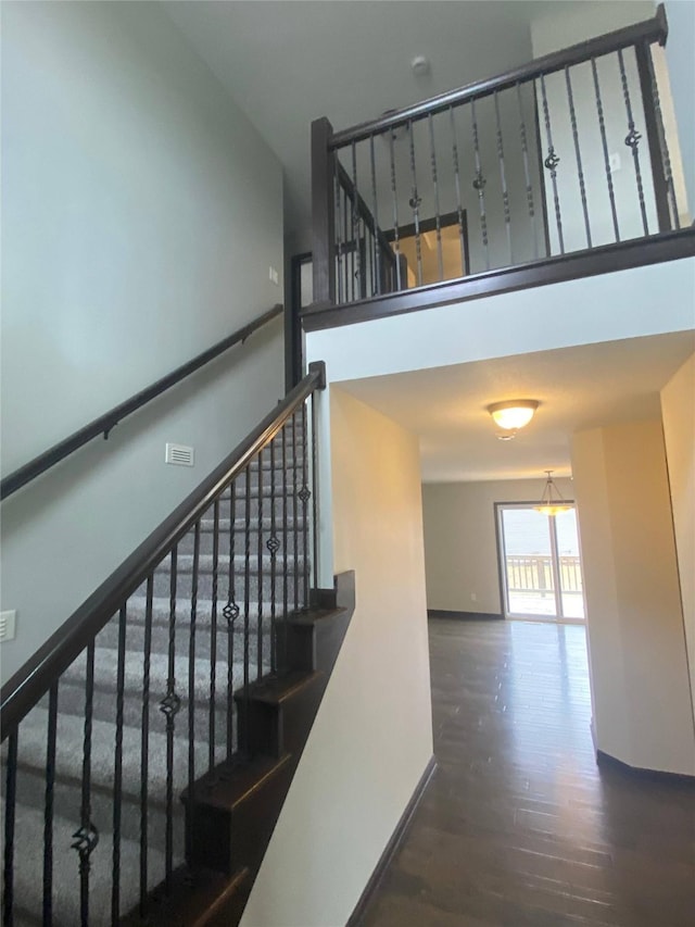 stairway featuring hardwood / wood-style floors and a high ceiling