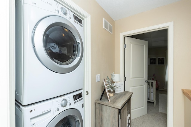 laundry area with stacked washing maching and dryer