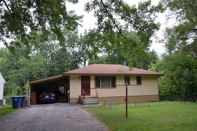 ranch-style home with a front yard, a carport, and cooling unit