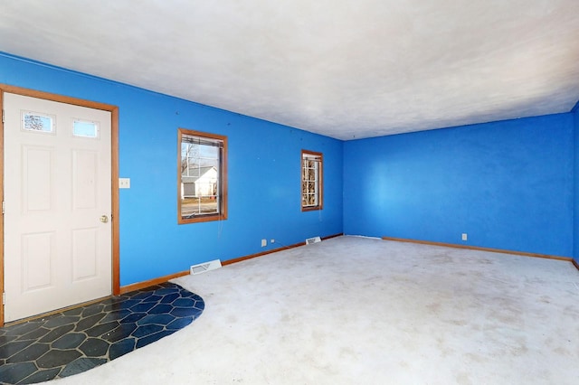 foyer with baseboards and visible vents