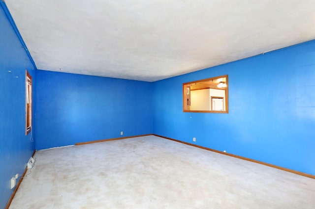 carpeted empty room with baseboards