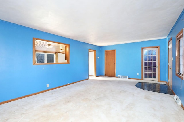 unfurnished room featuring baseboards, visible vents, and concrete flooring