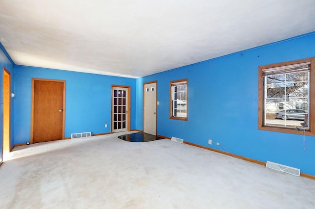 unfurnished room with baseboards and visible vents