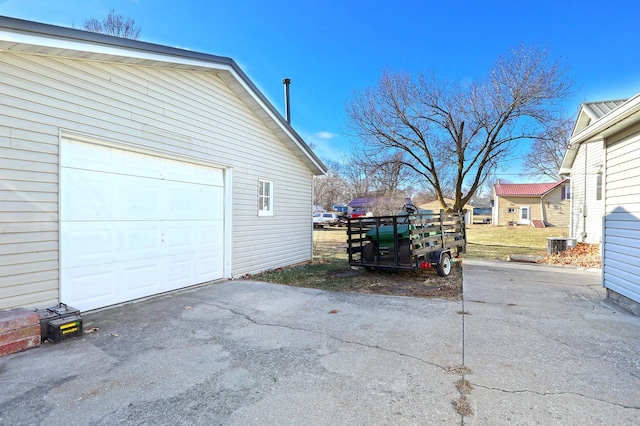 garage with driveway and cooling unit