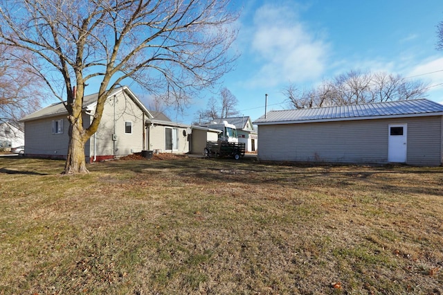 exterior space with metal roof and a yard