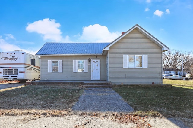 view of front facade with metal roof and a front lawn