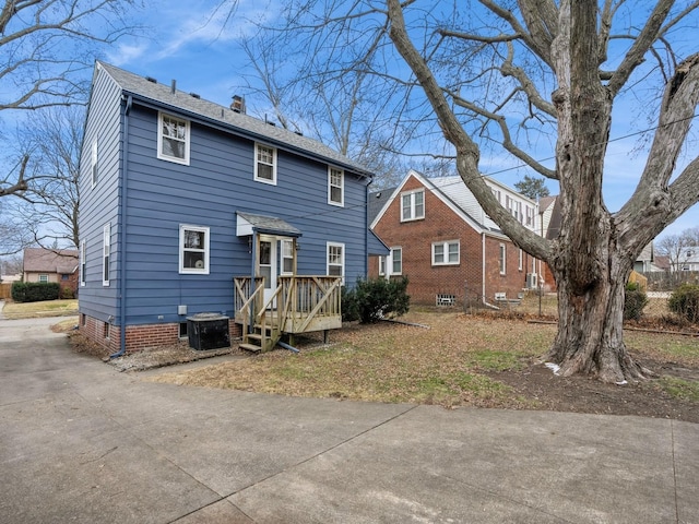 rear view of property with a wooden deck and cooling unit