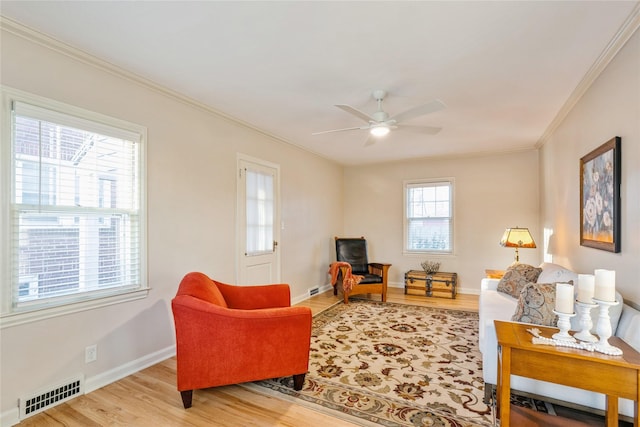 living room with ceiling fan, light hardwood / wood-style floors, and crown molding