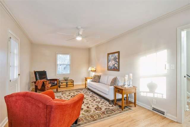 living room featuring light wood-type flooring, ceiling fan, and ornamental molding